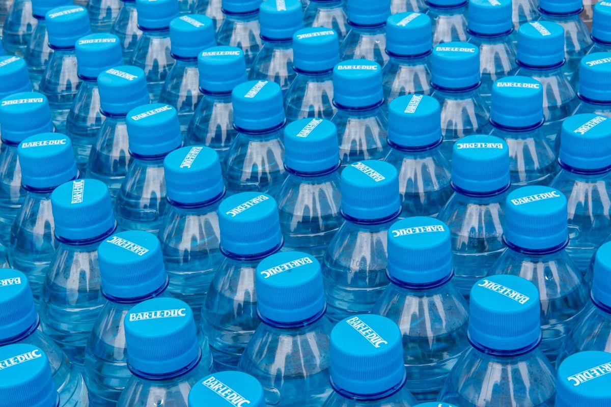 Réserve d'eau potable : packs de bouteilles d'eau du commerce stockées