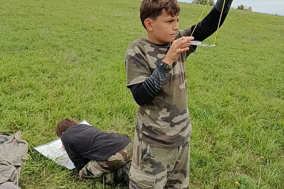 Jeune prenant un azimut à la boussole