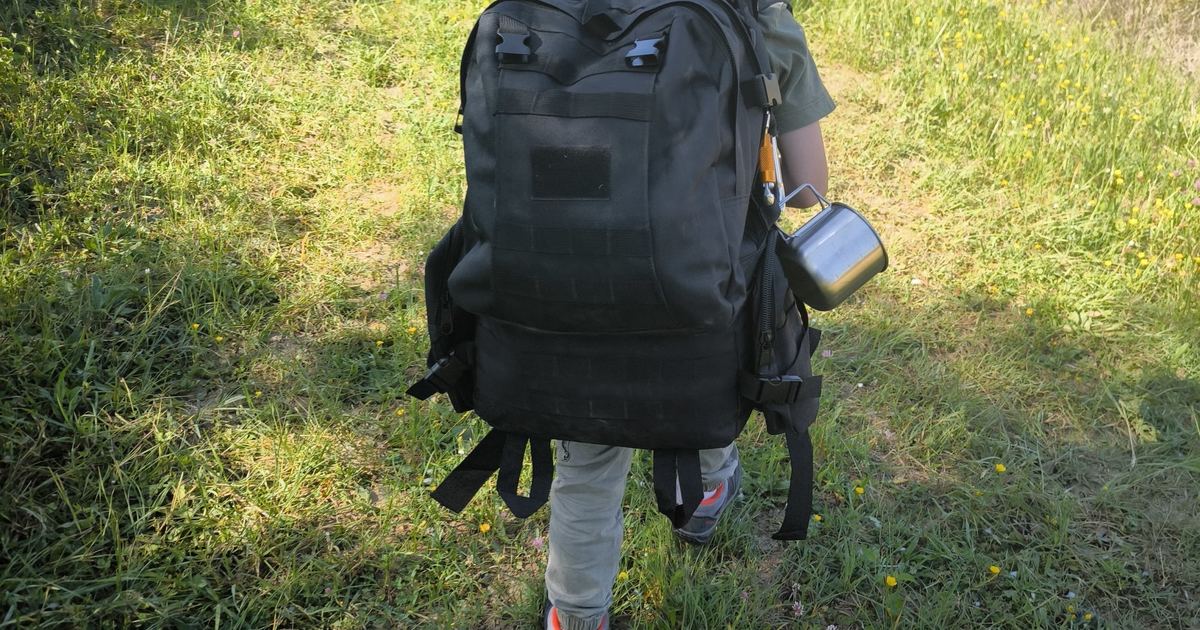 Participants progressant sac au dos sur un chemin forestier lors d'un stage de survie
