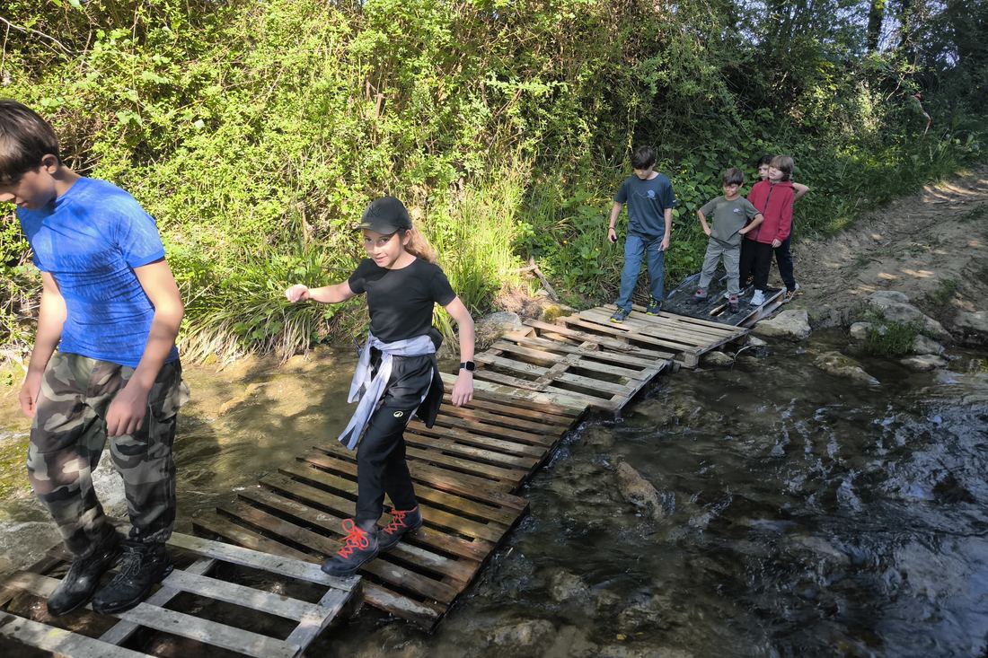 Franchissement encadré d'un ruisseau lors d'un stage nature en famille
